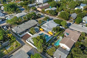 Vue aérienne d’un quartier résidentiel comprenant plusieurs maisons, une piscine et une cour clôturée.