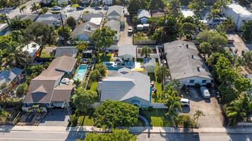 An aerial view of a residential neighborhood with houses, a swimming pool, and a street.
