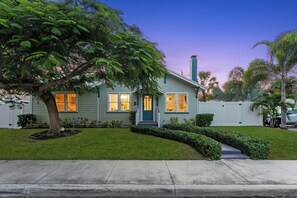 A two-story house with a front yard, a tree, and a white fence. - Tropical Pool Retreat / Heated Pool & Hot Tub / Minutes to Beach & Downtown (lake worth beach)