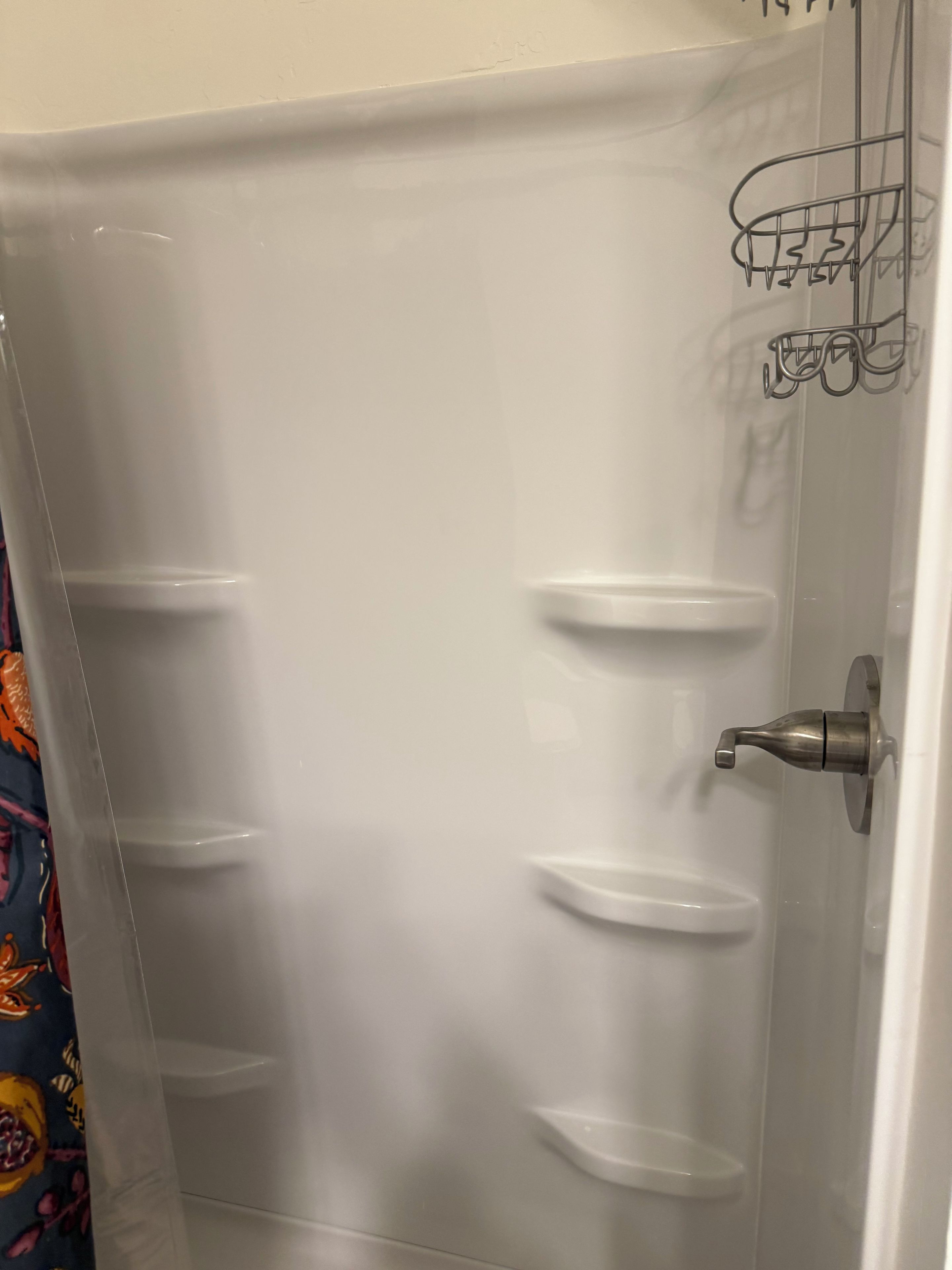 A bathroom with a white bathtub, a shower, and a toilet.