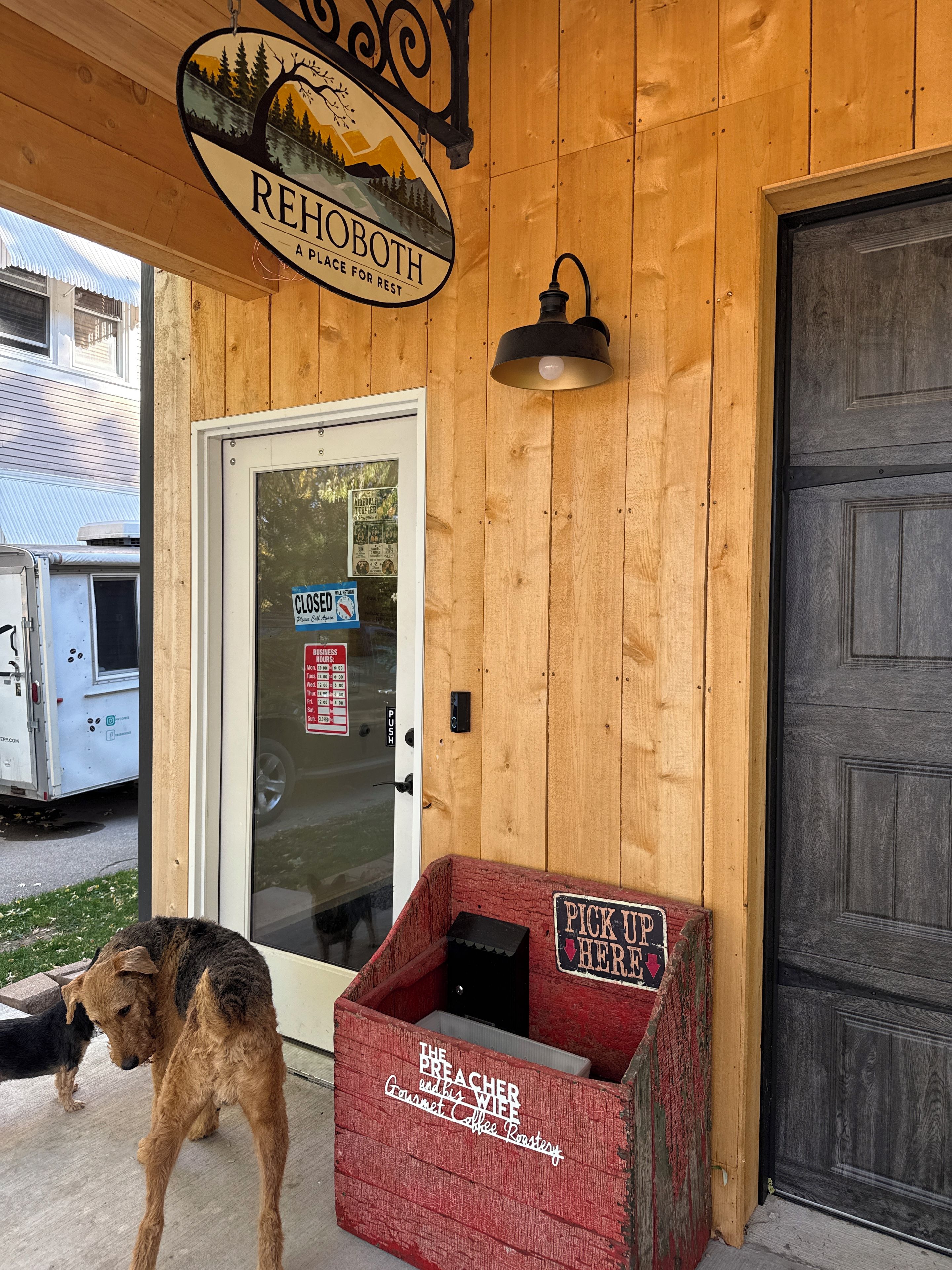 Un bâtiment en bois avec une enseigne indiquant « REHOBOTH, LIEU DE DÉTENTE » et une porte fermée sur laquelle est apposée une indication « POUSSER ».