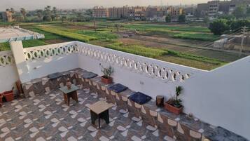 Una terraza con suelo estampado, zona de estar y plantas en macetas.