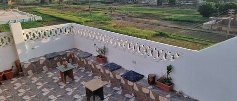 A terrace with a patterned floor, seating area, and potted plants.