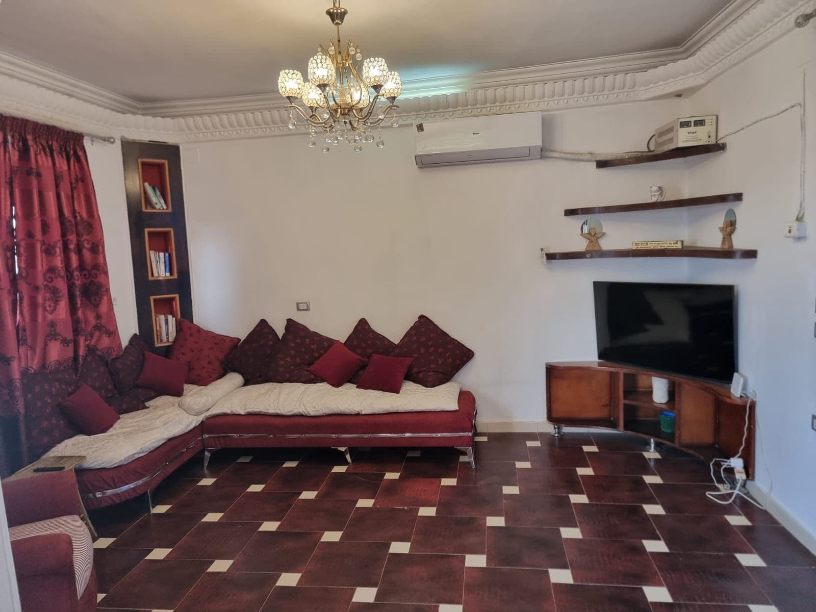 Een woonkamer met een bank, televisie en decoratieve objecten.