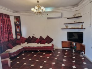 A living room with a sofa, television, and decorative items. - Adream apartment in Luxor (Luxor)