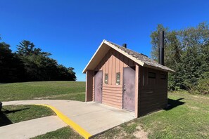 A small wooden building with a sloped roof, two doors, and a single chimney. - Luxury-private pool-across from beach (South Haven)