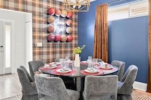 A dining room with a plaid wallpaper, a chandelier, and a neon sign. - 5 Min to Lucas Oil - Hot Tub - Arcade - Outdoor Movie - Propane Firepit (Indianapolis)