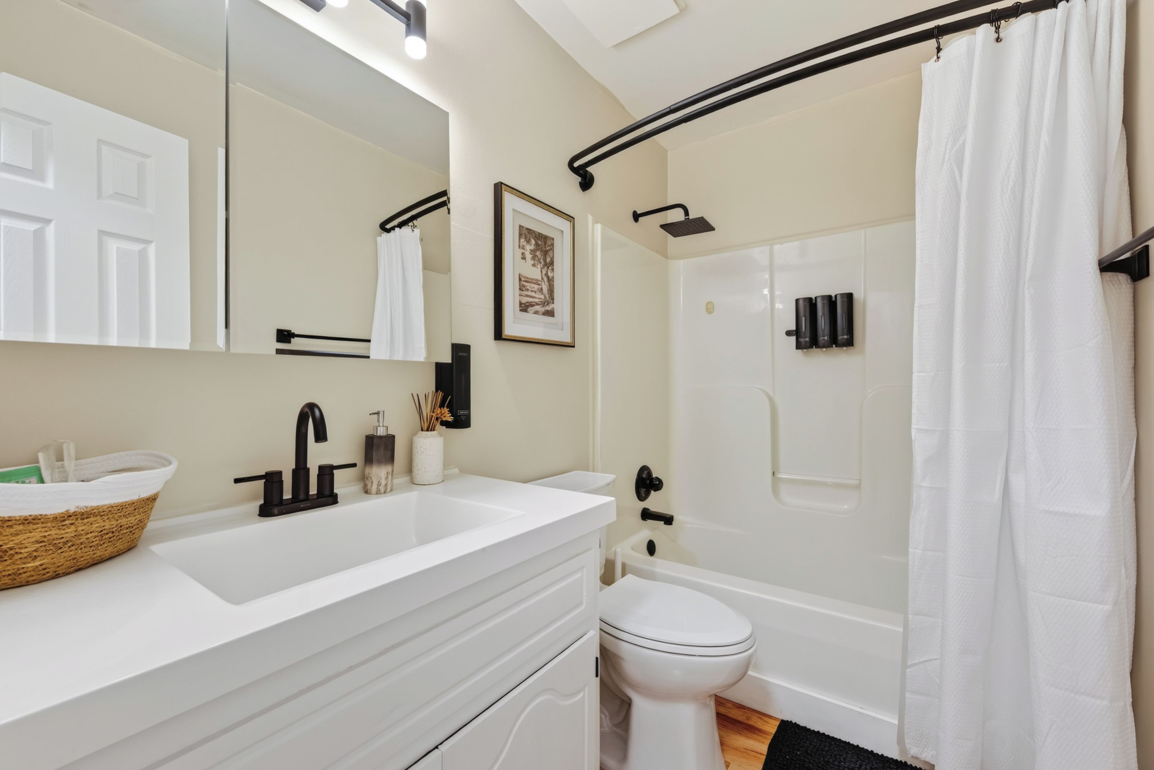 A modern bathroom with a white sink, a toilet, and a shower area.