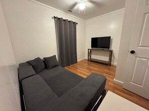 A bedroom with a bed, a television on a stand, a door, and a curtain. - Spacious 6-bedroom house in Walhalla, central to all the area attractions (Walhalla)