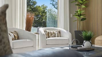 Una sala de estar moderna con un sofá, sillones y una mesa de centro.