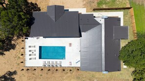A modern house with a large swimming pool, multiple decks, and a fenced backyard. - 3 Acre Luxury  Private Pool + Sports Court (Liberty Hill)