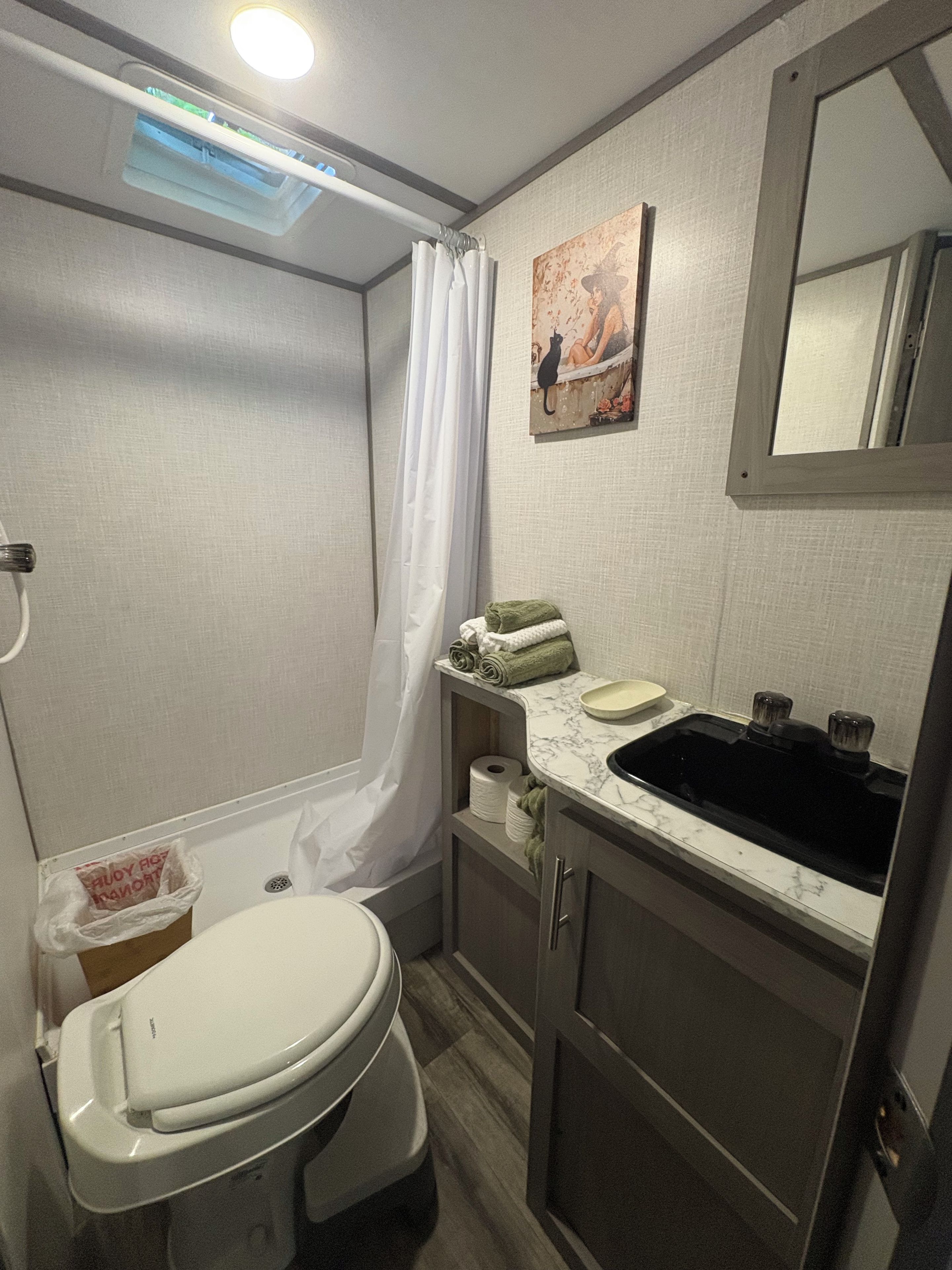 Ein kleines Badezimmer mit Toilette, Waschbecken und Dusche.