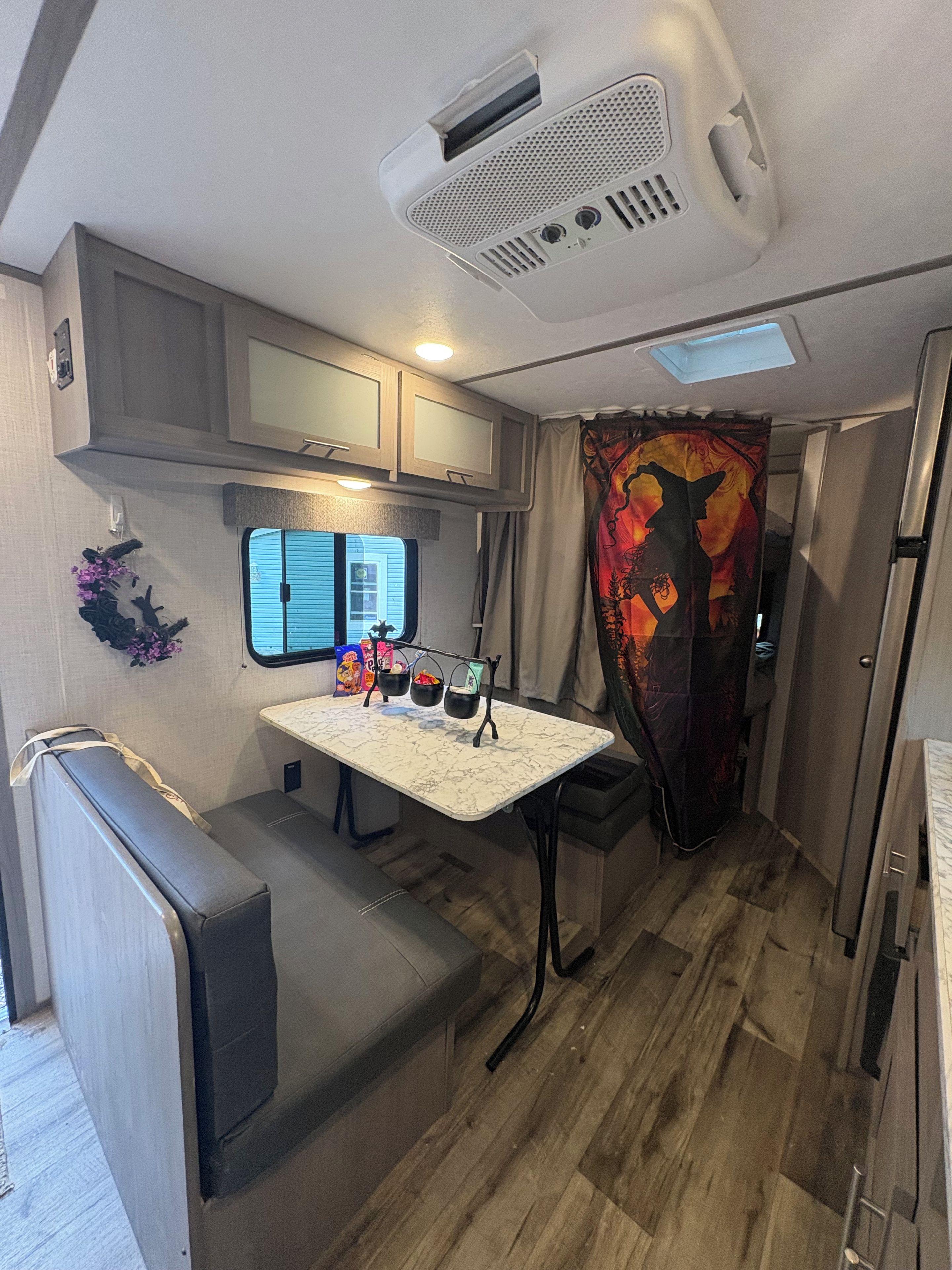 Cocina compacta para autocaravana con kitchenette, comedor y un pequeño espacio para sentarse.