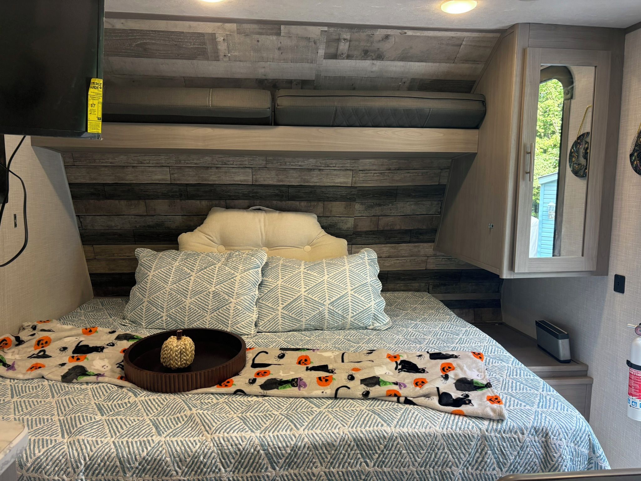 A bedroom with a bed, pillows, a blanket, and a decorative item.