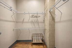 A laundry room with metal drying racks, a metal folding chair, and a concrete wall. - The Bentley Collection - The Retro Retreat (Dallas)