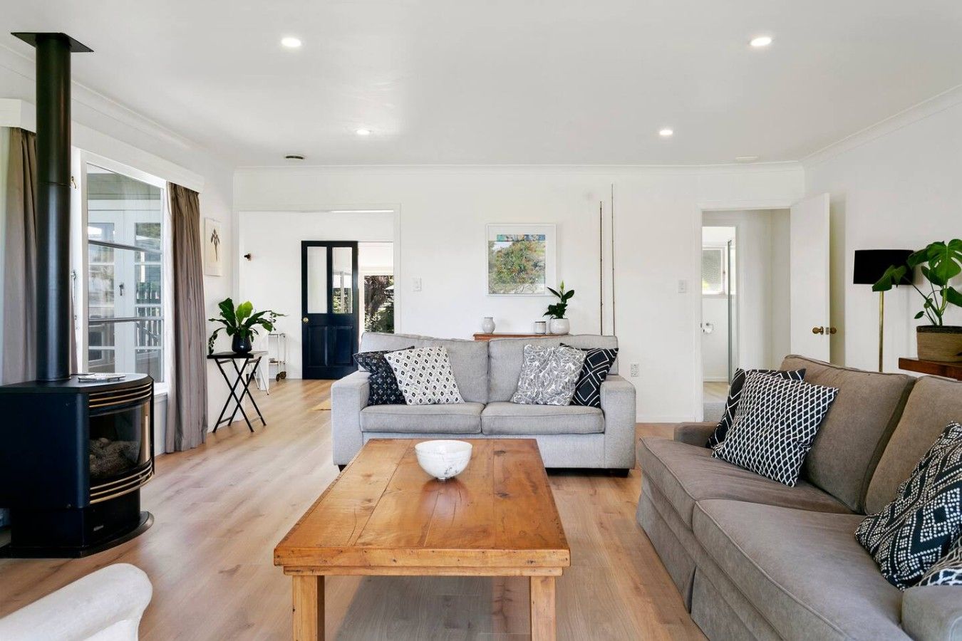 A modern living room with a sofa, coffee table, and a fireplace.