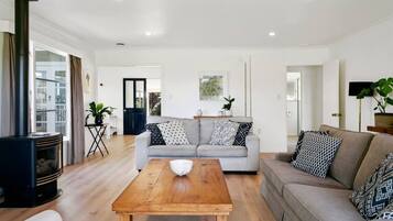 A modern living room with a sofa, coffee table, and a fireplace.