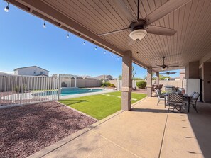 A covered patio area with a pool, outdoor furniture, and a view of the backyard. - Lovely 4-bedroom house with pool in charming Avondale (Avondale)