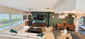 Ein Wohnzimmer mit einer Couch, einem Couchtisch und einem Essbereich mit Tisch und Stühlen.