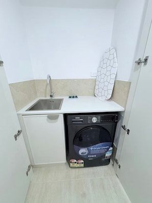 A compact kitchen with a sink, a dishwasher, and a drying rack. - City Center 1BR丨Steps from Lake丨with Parking (Canberra)