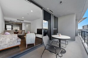 Un appartement moderne doté d’un balcon, d’un coin repas et d’un salon.