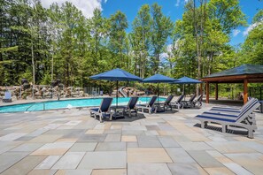 A pool area with lounge chairs and umbrellas, surrounded by trees. - Evergreen: NEW, Lake Access, Hot Tub, Dogs OK, Fire Pit, Accessibility Features (Oakland)