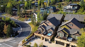 A residential area with multiple houses, a curved road, and a visible driveway leading to a garage. - Deer Valley Lodge by Avantstay Hot Tub + Cedar Sauna + Elevator + Game Lounge Walk to Main Street (Park City)