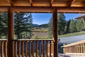 A wooden deck with a view of a mountainous landscape.
