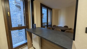 A room with a long table and chairs, large windows with stone walls, and a wooden ceiling. - The Little Prince - tucasaenlospirineos (Escarrilla)