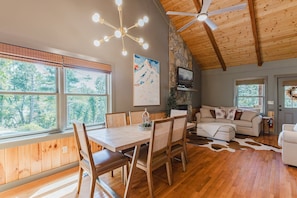 A wooden interior with a dining table, chairs, a sofa, and a ceiling fan. - A Cozy Mountain House Near Downtown Banner Elk (Banner Elk)