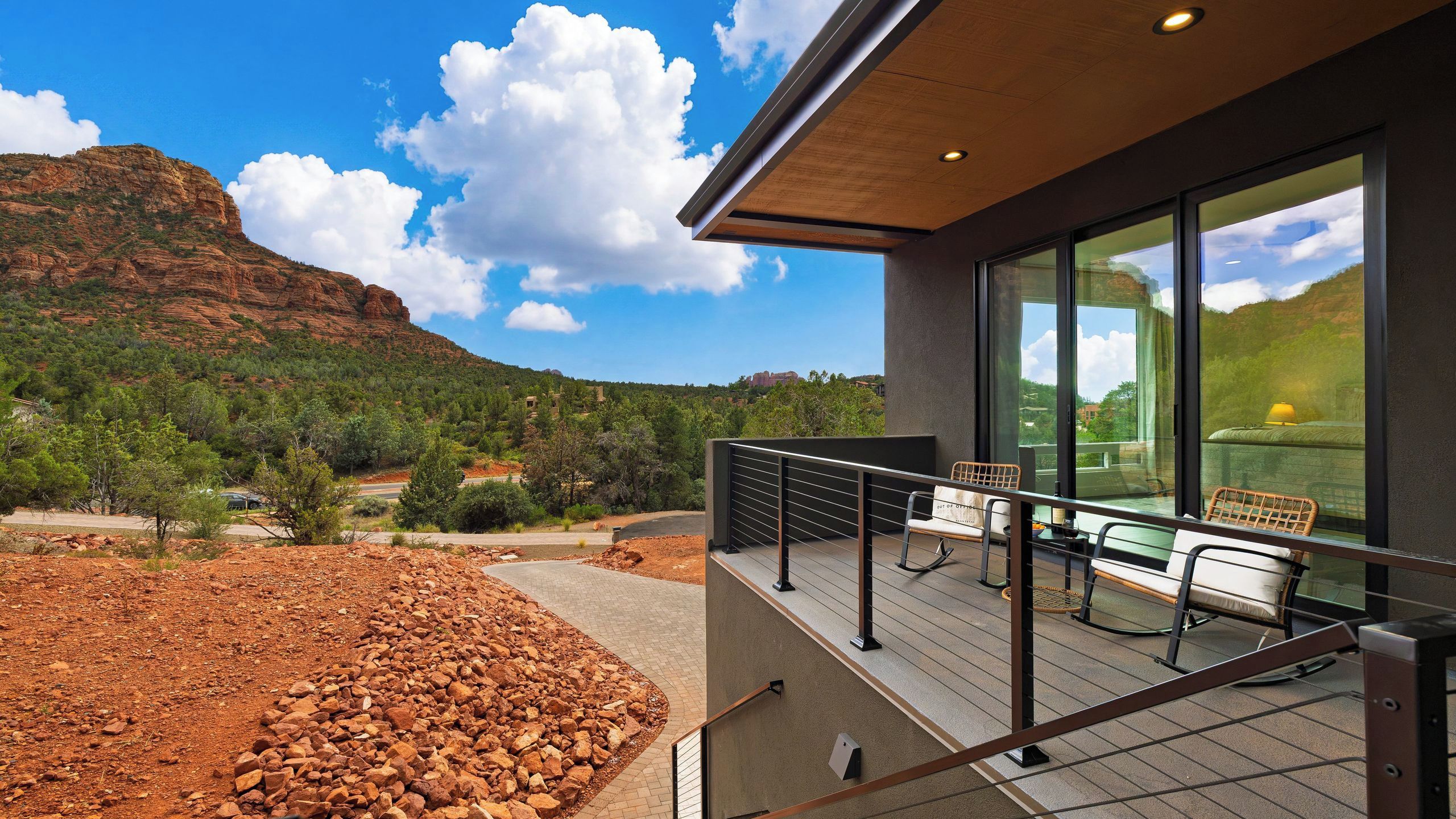 A modern building with a balcony overlooking a mountainous landscape.