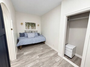 Ein Schlafzimmer mit einem Bett, einem Nachttisch und einem Kleiderschrank.