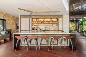 Une cuisine moderne dotée d’un îlot central, de tabourets de bar et d’un mur décoratif.