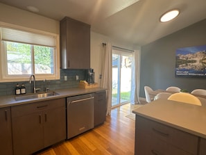 A modern kitchen with a dishwasher, a coffee maker, and a window with blinds. - Syringa House - 3 beds/2.5 baths Boise Retreat near Bown Crossing (Boise)