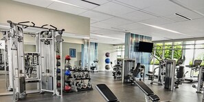A gym with various exercise equipment, including weight machines, free weights, and cardio machines. - Stunning 2-bedroom villa in Marco Island with many pools, gym, island views. (Marco Island)