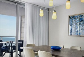 A dining area with a table, chairs, and a blue bowl. - Stunning 2-bedroom villa in Marco Island with many pools, gym, island views. (Marco Island)