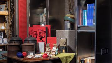 A display of traditional Chinese tea sets and ceramics, including teapots, teacups, and a vase, arranged on a table with a green cloth.