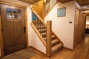 A wooden staircase with carpeted steps leading to a second floor. - Roaring River Lodge - Riverfront, Fire Pit, EV (Rhododendron)