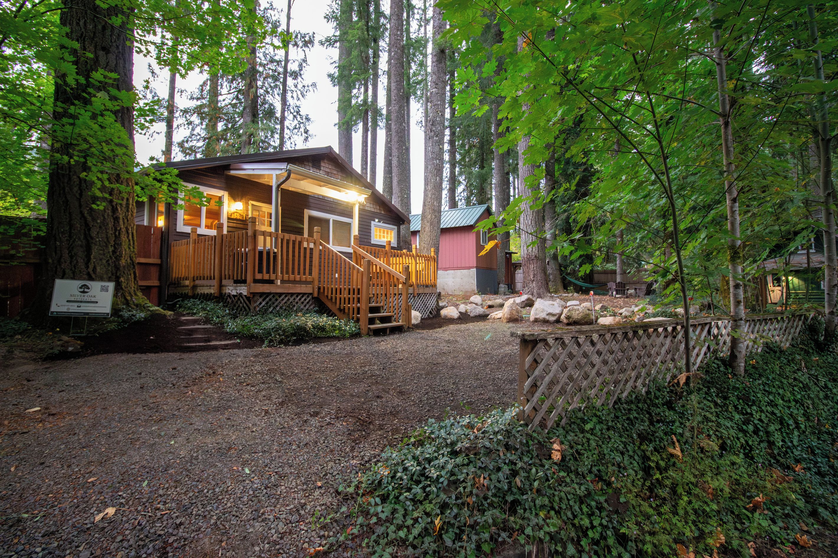 A lodge with a wooden deck, a covered porch, and a gravel driveway.