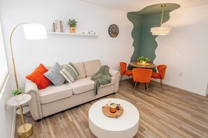 Un salon moderne avec un canapé, une table basse et un coin repas.