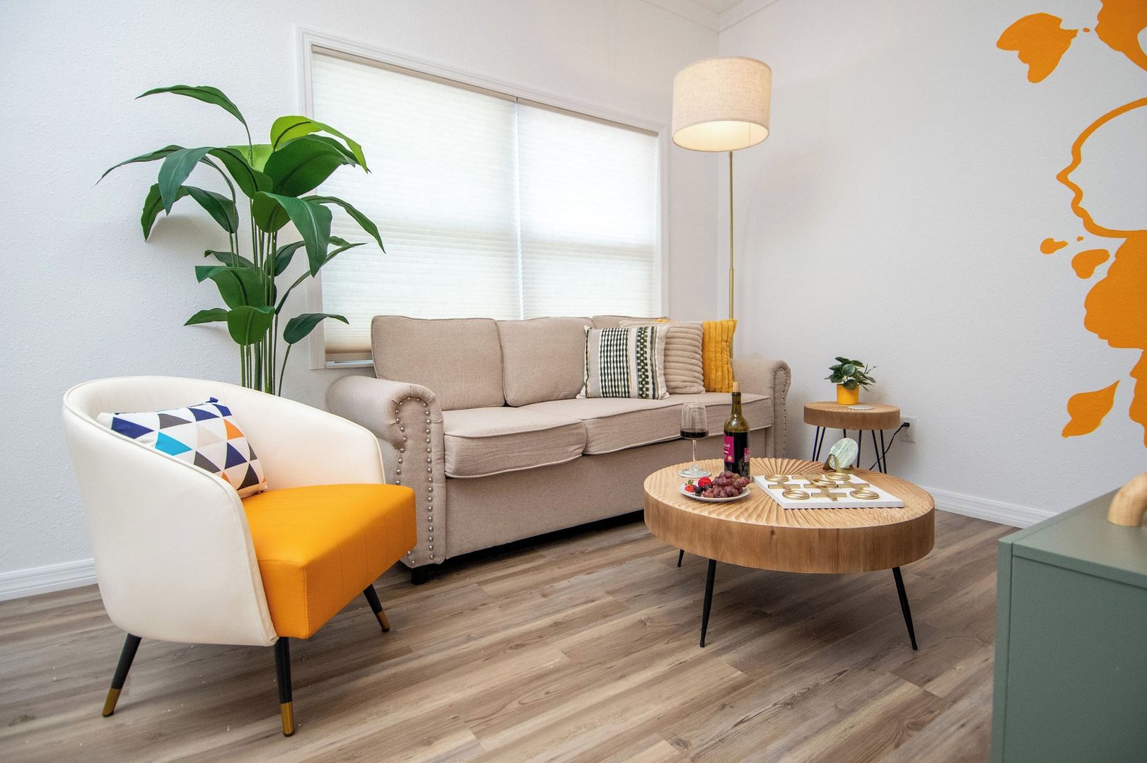 Ein Wohnzimmer mit einer Couch, einem Sessel, einem Couchtisch und einem Blumentopf.