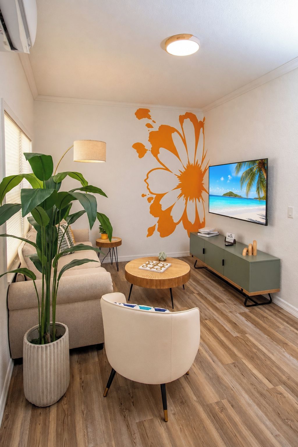 A modern living room with a sofa, a round coffee table, a potted plant, a TV, and a decorative wall mural.