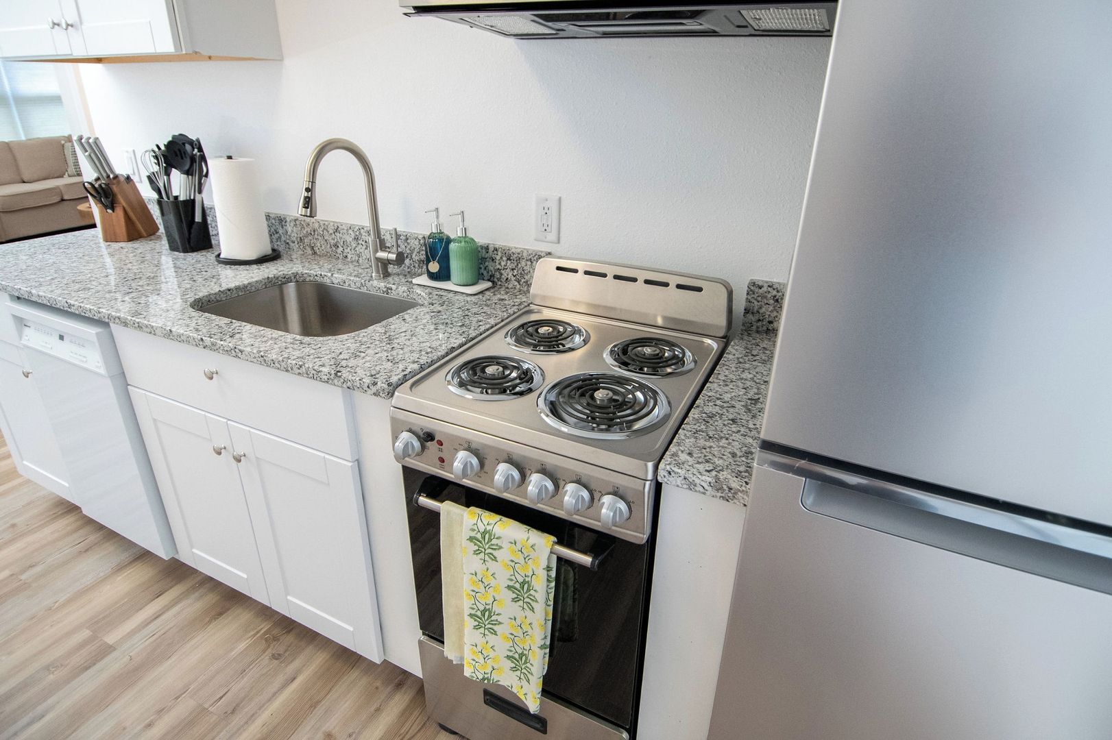 A kitchen with a stainless steel stove, a sink, and a dishwasher.
