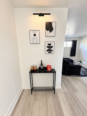Ein modernes Wohnzimmer mit einem schwarzen Couchtisch, gerahmten Kunstwerken und einem schwarzen Sofa.