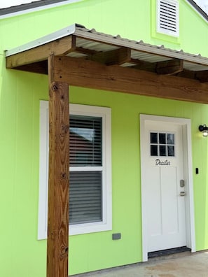 A building with a green exterior, a white door labeled 'Decatur,' and a wooden post. - Two Private Homes | 5 King Bedrooms | Sleeps 10 (Lafayette)