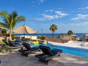 A pool area with lounge chairs and a view of the ocean. - Beautiful "Villa De Familia" Partial Ocean View (Baja California Sur)