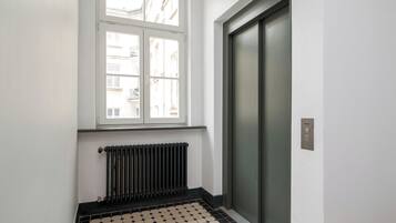 A room with a radiator, a window, and a door.