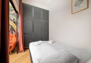 Ein Schlafzimmer mit Bett, Kleiderschrank und Stuhl.