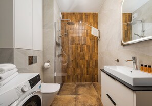 Un bagno moderno con doccia, WC e lavandino.