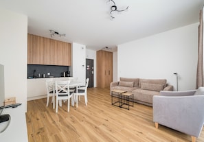 Eine moderne Wohnung mit Essbereich, Küchenzeile und Wohnraum.